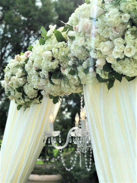 wedding ceremony fabric and flower arch with chandelier, valencia hyatt hotel in the rose garden