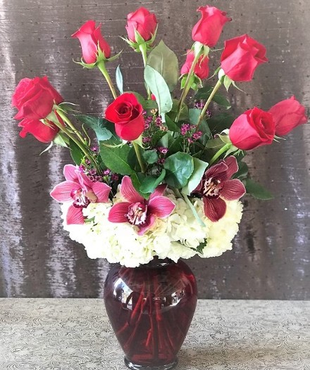 Dozen Red Long Stem Roses upgraded with cymbidium orchids, white hydrangeas and ruby red glass vase.