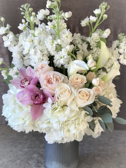 White, cream, and blush flower arrangement with height. 