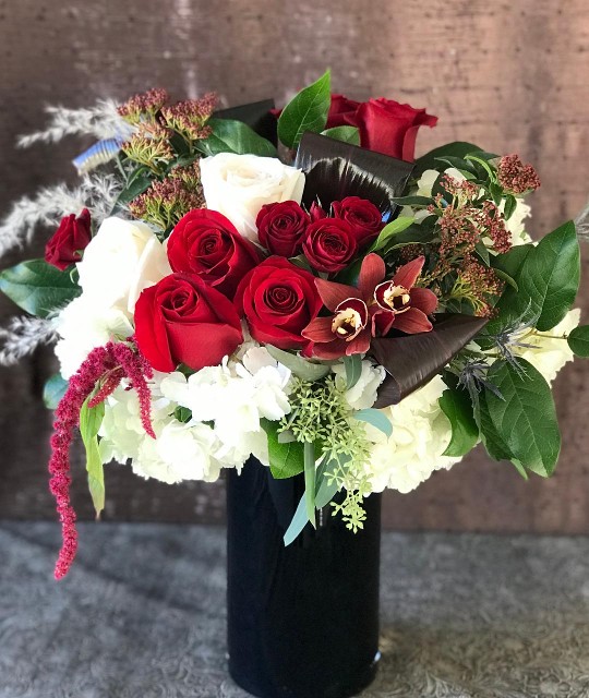Red roses in large 10 inch tall black glass vase, full of lots of beautiful textures.