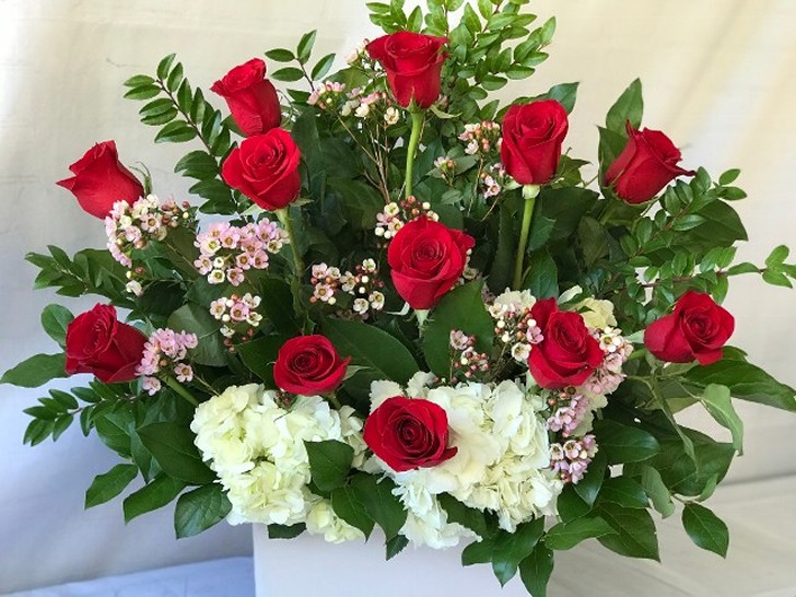 One dozen red long stem Ecuadorian  roses designed with white hydrangea and high end greenery. 