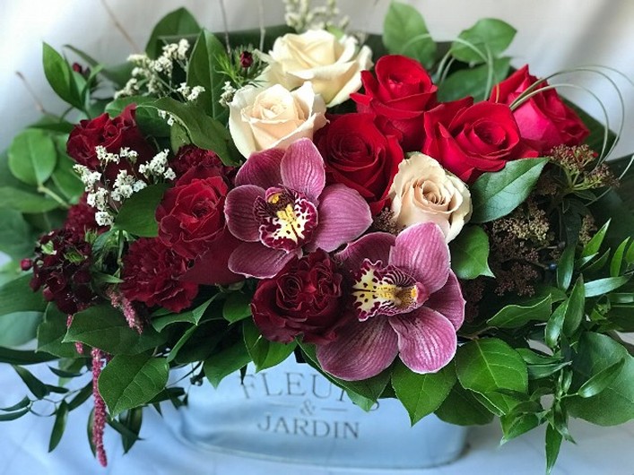 Fleurs & Jardin metal container filled with 12 premium blooms. Red roses, burgundy garden roses, burgundy dianthus, burgundy hanging amaranthus, viburnum tinus and cymbidium orchids.